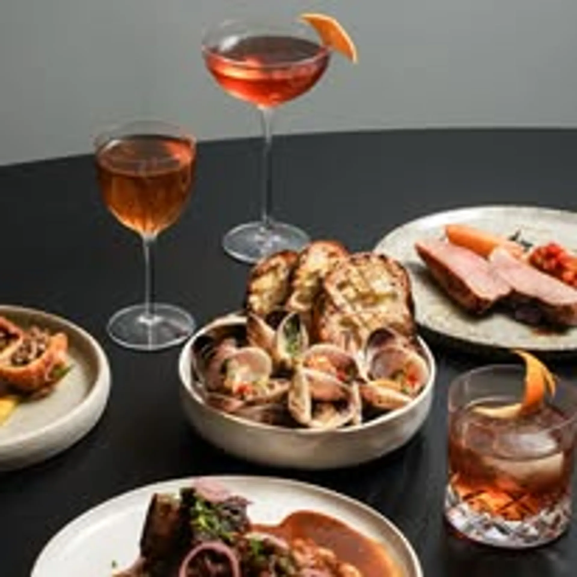 Una Una dinner table spread with multiple courses and cocktails