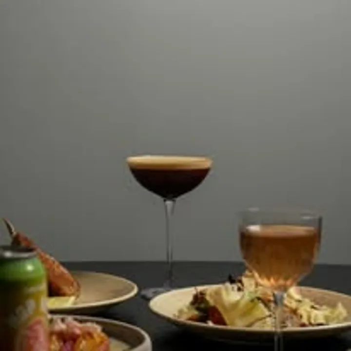 Espresso martini coupe alongside dinner plates